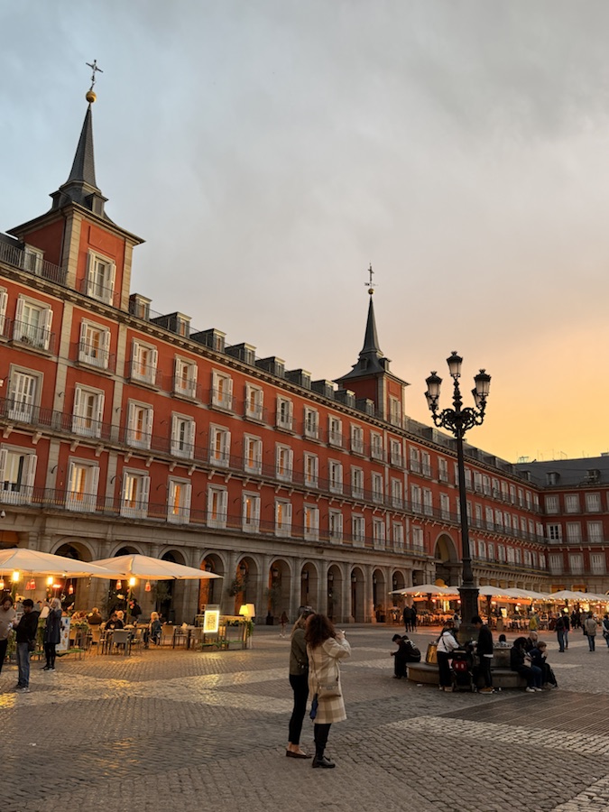 Plaza Mayor in Madrid at sunset with restaurants under the arcades