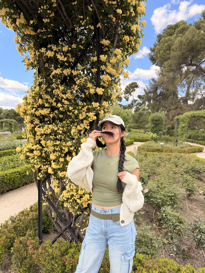 Standing under yellow flowers in Retiro Park Madrid