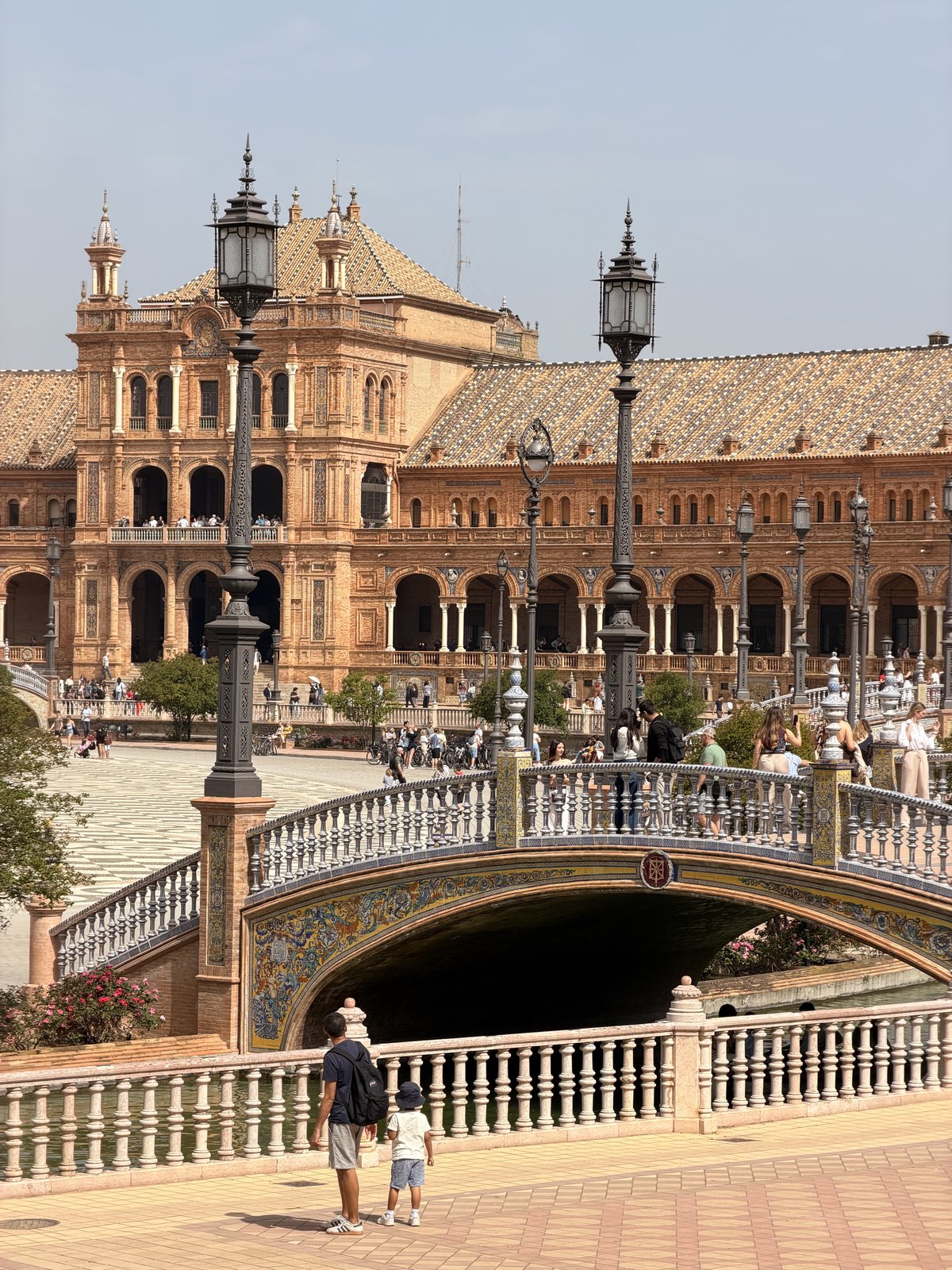 A tiled bridge arching over the canal at Plaza de España in Seville
